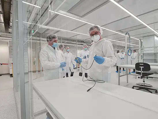 Personal científico con batas y guantes trabajando en un laboratorio limpio y moderno.