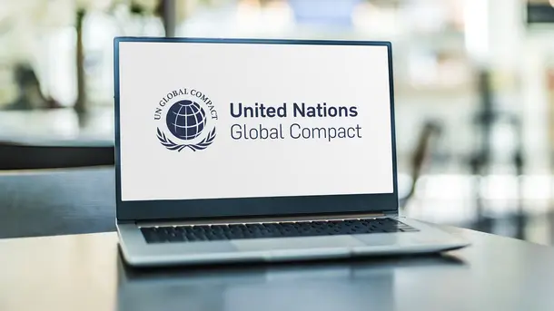 Laptop displaying United Nations Global Compact logo and text on screen.