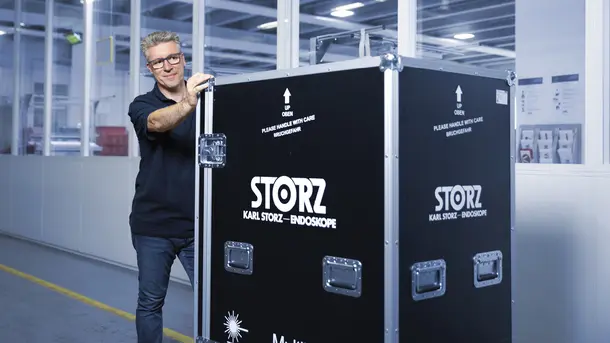 Person moving a large Karl Storz branded equipment case in an industrial setting.