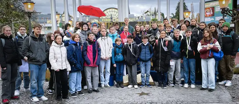 Große Gruppe von Jugendlichen steht gemeinsam für ein Gruppenfoto im Freizeitpark.