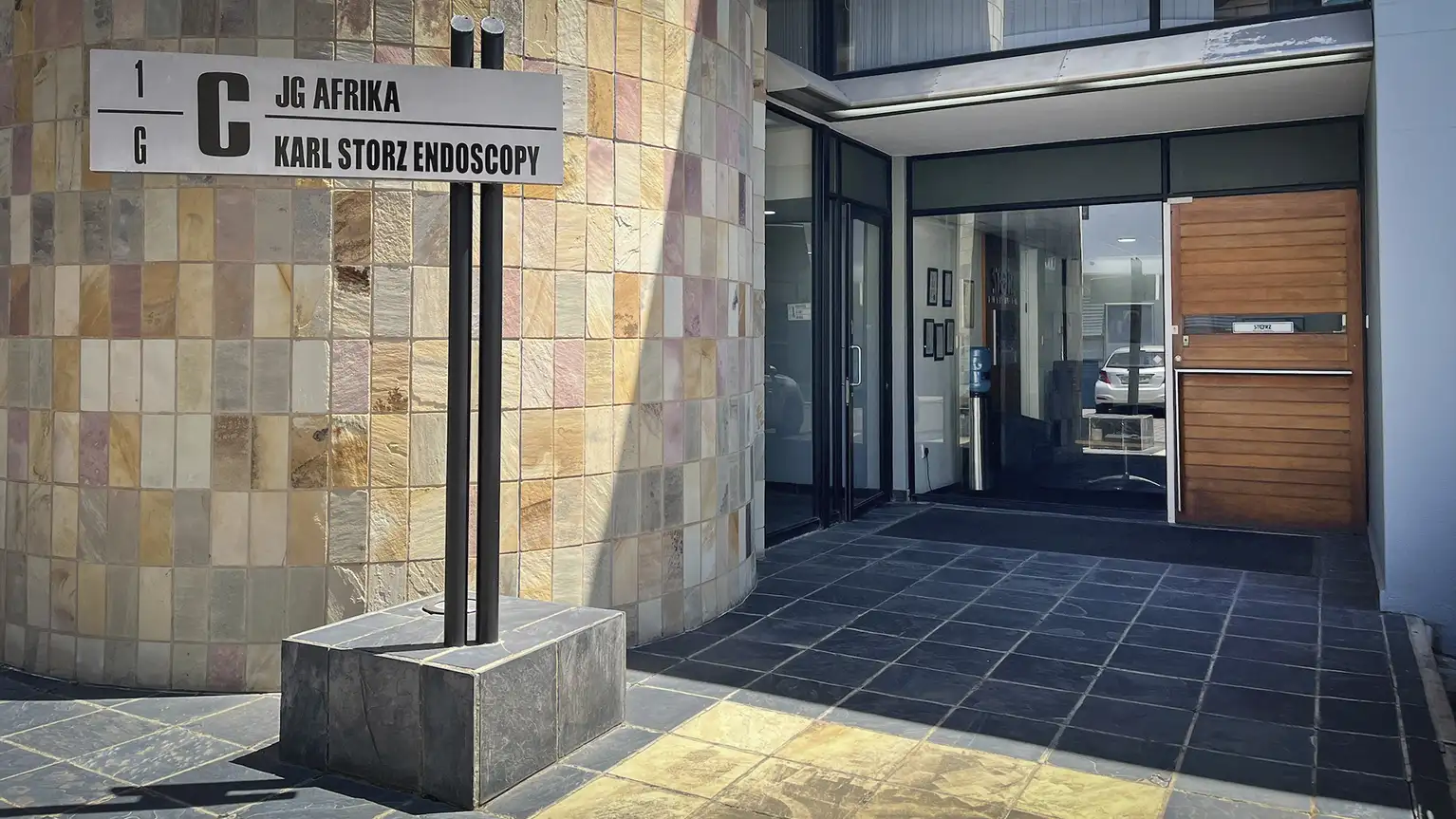 Вход в офисное здание с табличкой, на которой указаны JG Afrika и Karl Storz Endoscopy.