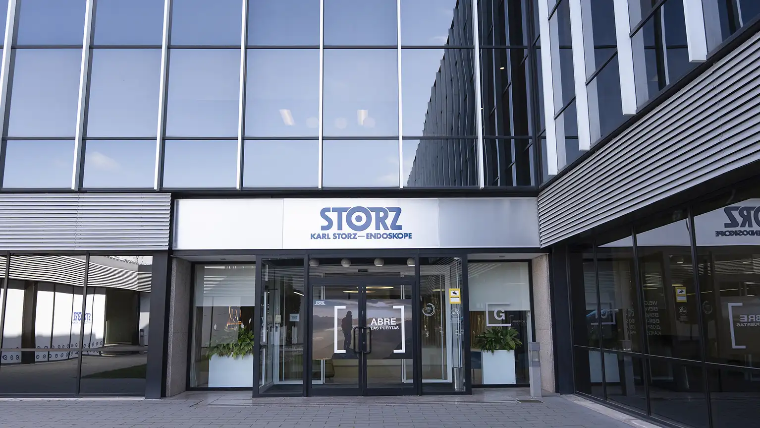 Вход в здание Karl Storz Endoskope, видны логотип и стеклянные двери.