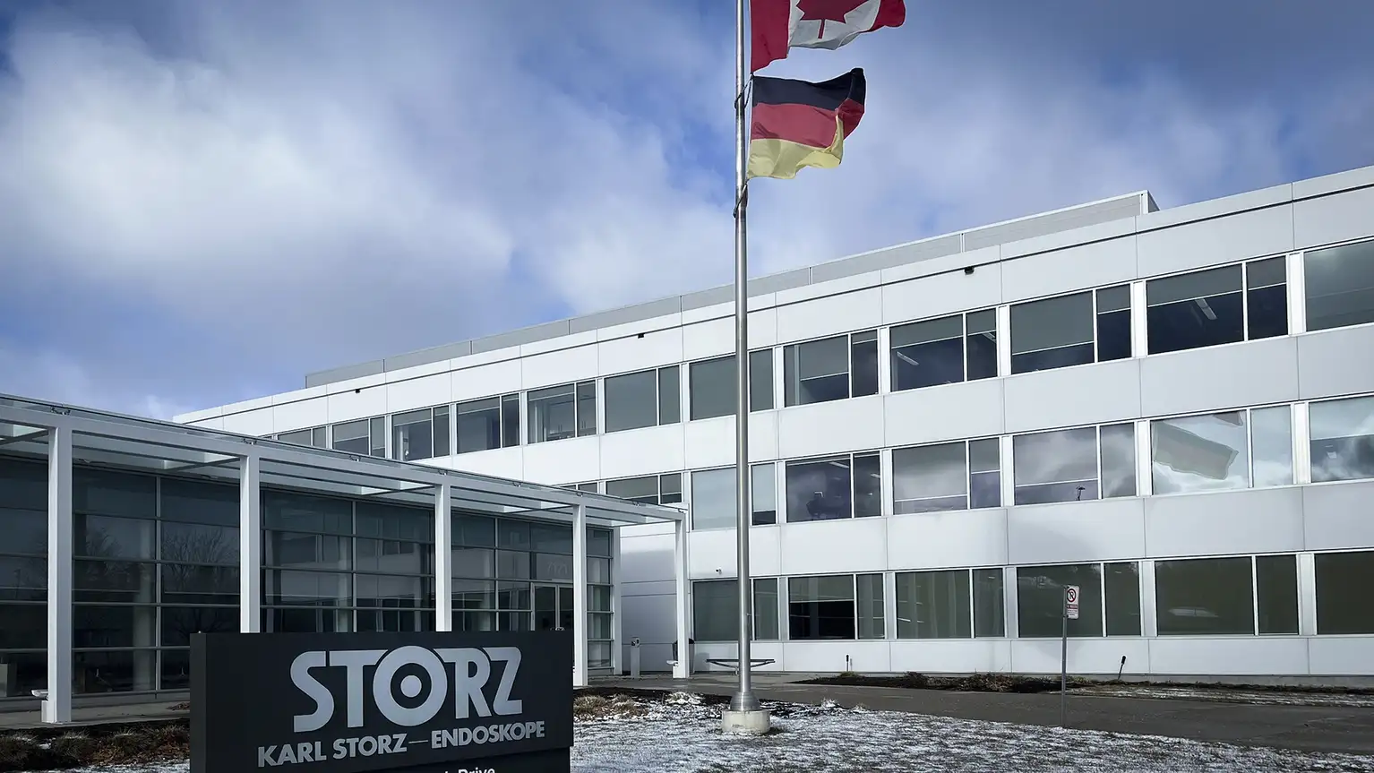 Front view of the KARL STORZ Endoskope office building with company sign and two flags.