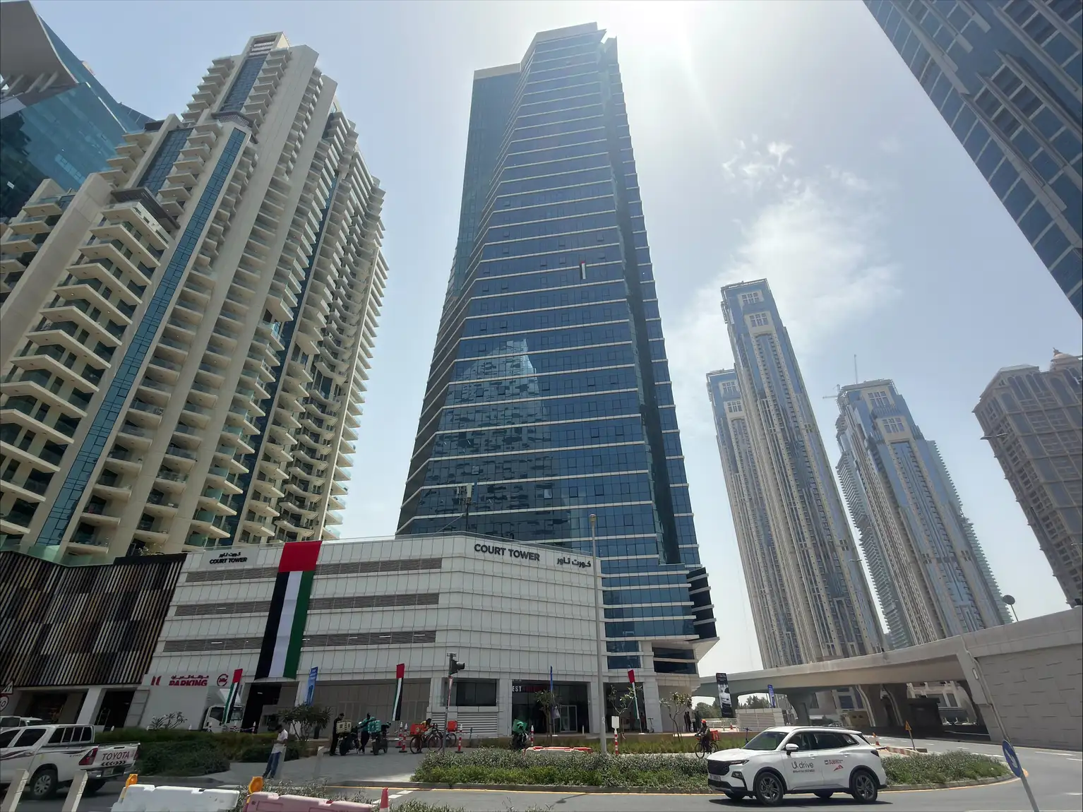 Rascacielos modernos y Court Tower en una zona empresarial de Dubái bajo cielo soleado.