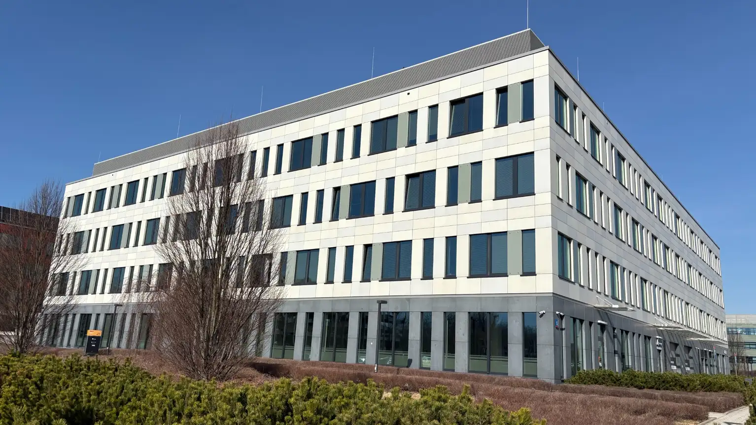 Modern office building with large windows and white facade.