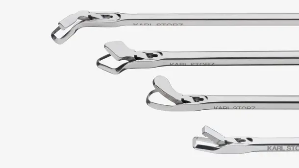 Close-up view of four stainless steel surgical forceps with varying tip designs.