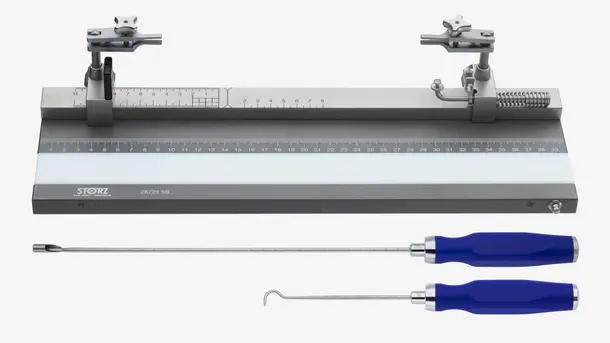 Orthopedic measuring device with graduated ruler and two surgical instruments with blue handles.