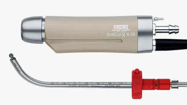 Medical drill handpiece with curved surgical attachment and red connector.