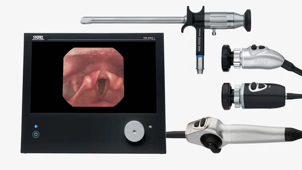 Laryngoscopy equipment with a monitor showing an image of vocal cords and medical endoscope attachments.