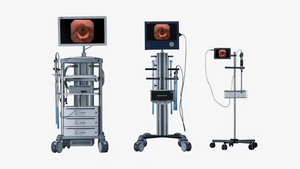 Three types of endoscopy equipment on wheeled carts with monitors displaying a larynx image.