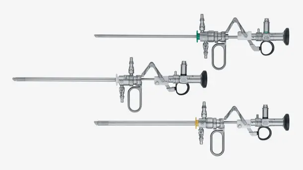 Three rigid metal endoscopic resectoscopes arranged horizontally for urological surgical procedures.