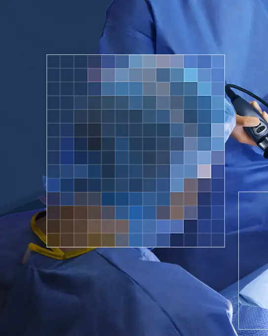 Surgeon holding a medical device in blue surgical gown.