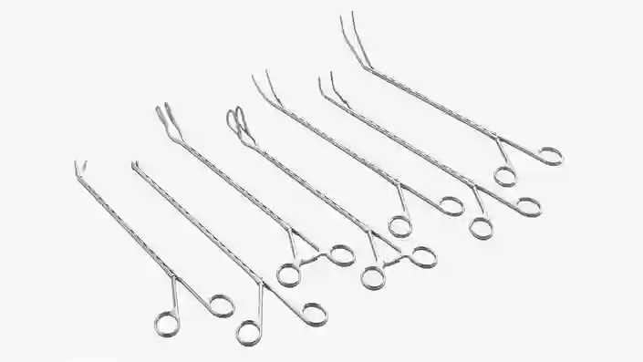 Set of long metal surgical forceps with different angled tips arranged side by side.