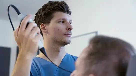 Medical professional performing an ultrasound examination on a patient.