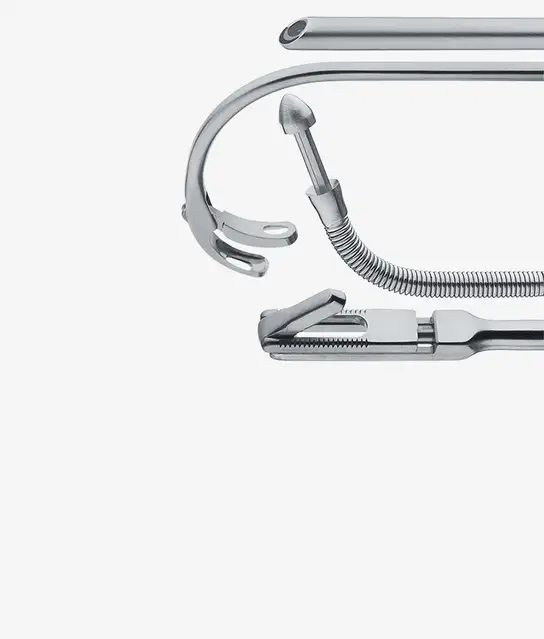 Close-up of various stainless steel surgical instruments arranged horizontally.